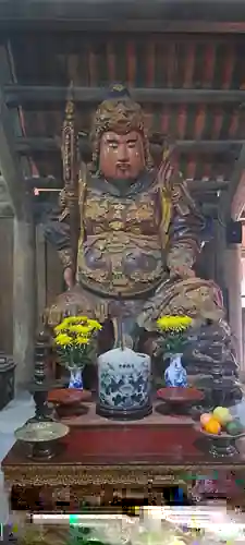 A large protective figure within Bút Tháp’s sculptural ensemble.