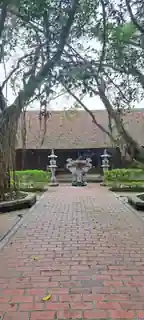 Courtyard, incense burner and timber hall beneath mature trees.